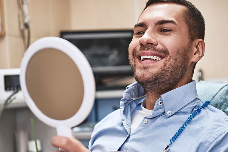 dental patient smiling in mirror